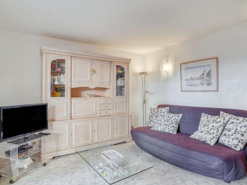 un salon avec un canapé violet et une télévision dans l'établissement Apartment Bibi Beaurivage by Interhome, à Biarritz