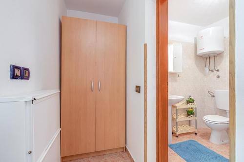 y baño con aseo y armario de madera. en Apartments Grgeta Funtana, en Funtana