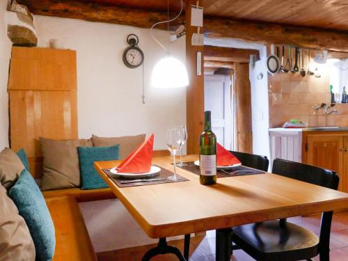 een tafel met een fles wijn en een wijnglas bij Holiday Home Scateto 66 by Interhome in Malvaglia