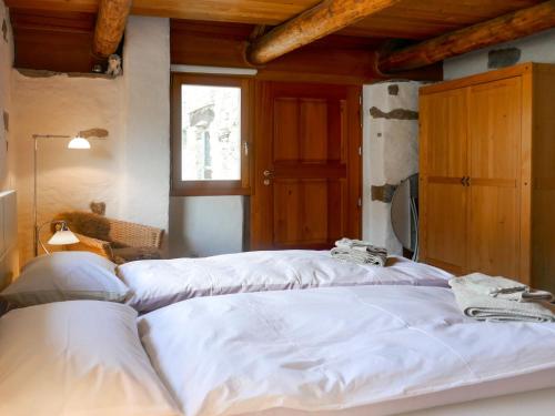 a large white bed in a room with a window at Holiday Home Rustico Scateto 66 by Interhome in Malvaglia