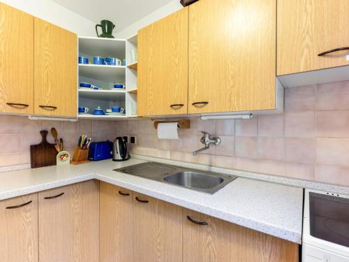a kitchen with wooden cabinets and a sink at Holiday Home Měřín by Interhome in Rabyně