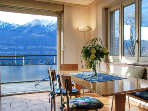 a dining room with a table with a vase of flowers at Apartment San Quirico by Interhome in Minusio
