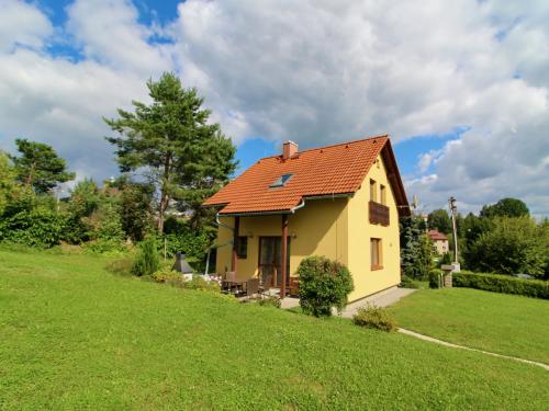 a yellow house with a red roof on a green field at Holiday Home Zásada by Interhome in Zásada