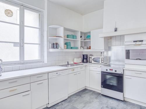 une cuisine blanche avec des armoires blanches et une fenêtre dans l'établissement Apartment Saint Vincent by Interhome, à Saint-Malo