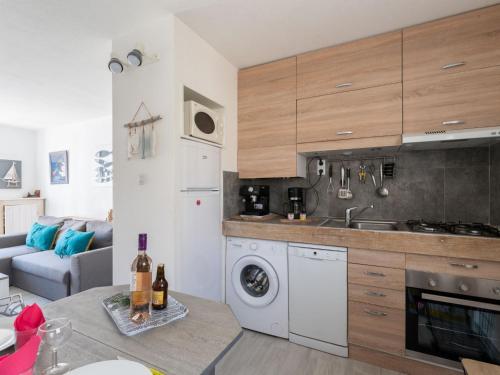 een keuken met een wasmachine en een woonkamer bij Holiday Home Les Maisons de la Plage-12 by Interhome in Le Grau-du-Roi