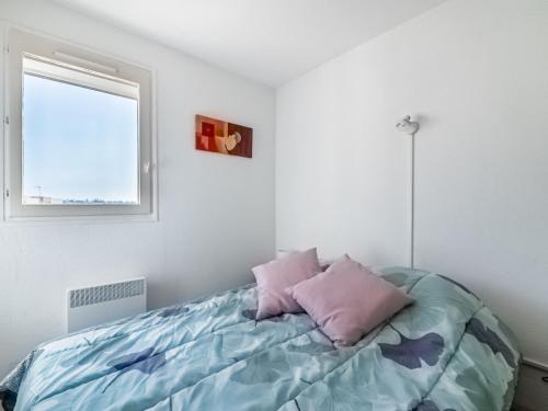 une chambre avec un lit avec des oreillers roses dessus dans l'établissement Apartment Terrasses de la Baronnie-5 by Interhome, au Grau-du-Roi