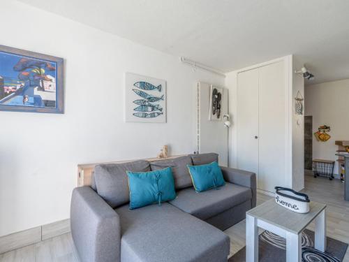 un salon avec un canapé et une table dans l'établissement Holiday Home Les Maisons de la Plage-12 by Interhome, au Grau-du-Roi