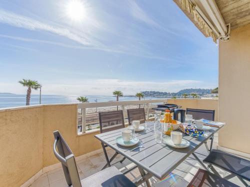 une salle à manger avec une table et des chaises et l'océan dans l'établissement Apartment Le Palazzo del Mar-11 by Interhome, à Cavalaire-sur-Mer
