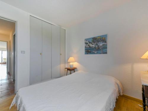 - une chambre blanche avec un lit blanc et une lampe dans l'établissement Apartment Rose des Sables-14 by Interhome, à Canet