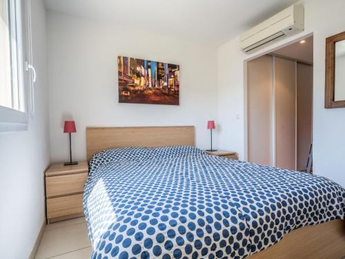 een slaapkamer met een bed met een blauw en wit dekbed bij Apartment Presqu'île de la Lagune-3 by Interhome in Saint-Cyprien