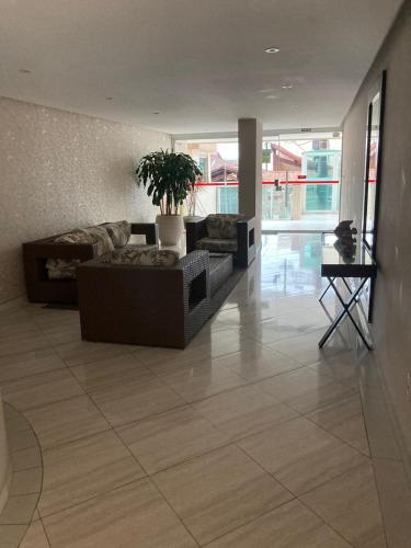 a living room with a couch and a table at Pé na areia Fábio e Silvia in Praia Grande