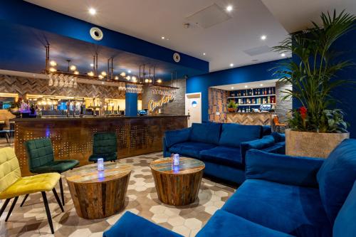 a lobby with blue couches and a bar at Weetwood Hall Estate in Leeds