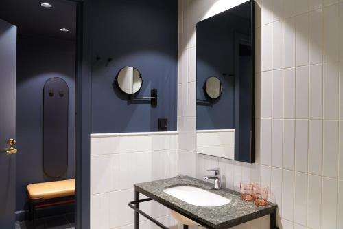 a bathroom with a sink and two mirrors at Solo Sokos Hotel Helsinki in Helsinki