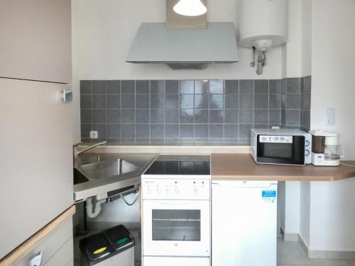 una pequeña cocina con fregadero y microondas en Apartment Dittert by Interhome, en Lichtenstein