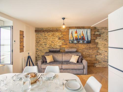 ein Wohnzimmer mit einem Tisch und einem Sofa in der Unterkunft Apartment Le point du jour 1 by Interhome in Cancale