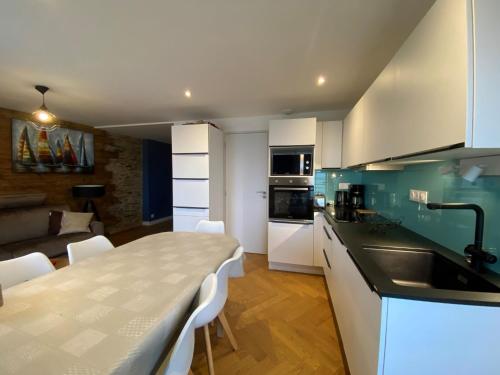 une cuisine et un salon avec une table et des chaises dans l'établissement Apartment Le point du jour 1 by Interhome, à Cancale