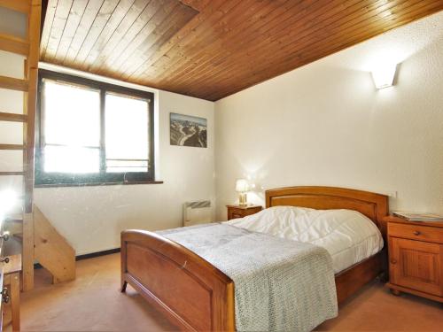 une chambre avec un lit en bois et une fenêtre dans l'établissement Apartment Champraz-16 by Interhome, à Chamonix-Mont-Blanc