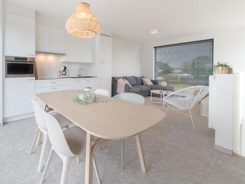 a kitchen and living room with a table and chairs at Holiday Home Bredunepark-2 by Interhome in Bredene