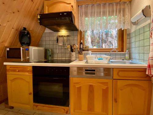 a kitchen with a stove and a microwave at Holiday Home Gräfenroda by Interhome in Dörrberg
