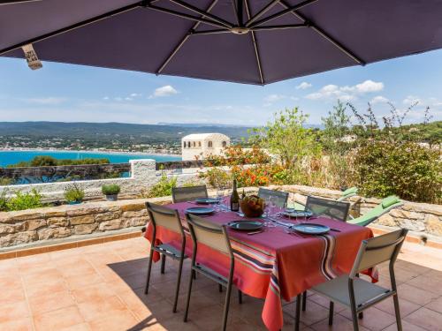 - une table et des chaises sur une terrasse avec un parasol dans l'établissement Apartment Hameau la Madrague-27 by Interhome, à Saint-Cyr-sur-Mer