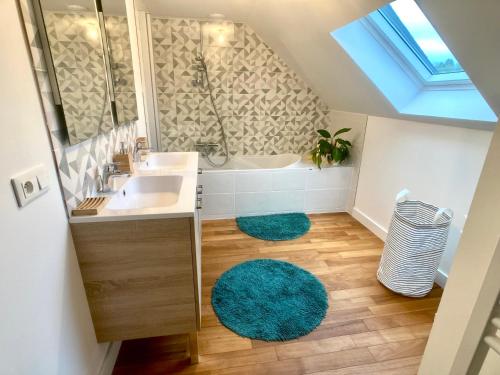 a bathroom with a sink and a tub and a rug at LA MAISON D'ALPHONSE, charmante, centre historique 4-6pers in Quimperlé