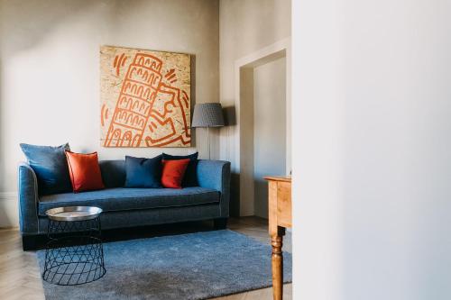 a living room with a blue couch with orange pillows at Palazzo Feroci - Residenza d'epoca in Pisa