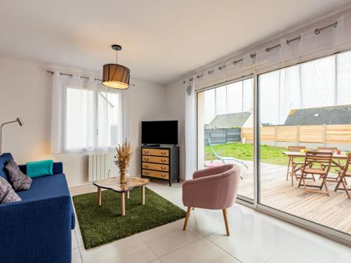 un salon avec un canapé bleu et une table dans l'établissement Holiday Home Océane by Interhome, à Barneville-Carteret