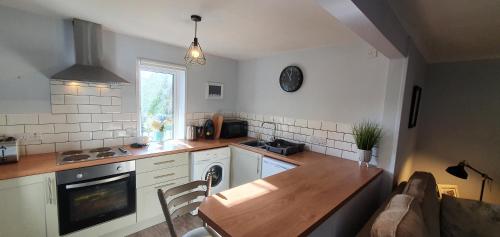 a kitchen with a wooden table and a dining room at Elmbank Garden Apartment in Oban