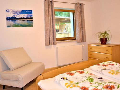 a bedroom with two beds and a chair and a window at Apartment Wiesenhof by Interhome in Reith bei Seefeld