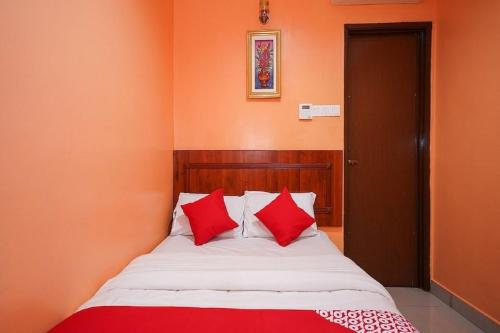 a bed with red pillows in a room at Bercam Times Inn Hotel in Ipoh