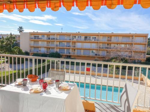 a table on a balcony with a view of a building at Apartment Les Cyclades-9 by Interhome in Le Lavandou