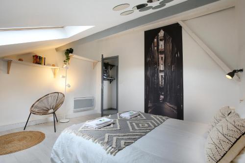 une chambre avec un lit et une chaise dans l'établissement expat renting - Le Houdini - Confort et Evasion, à Toulouse