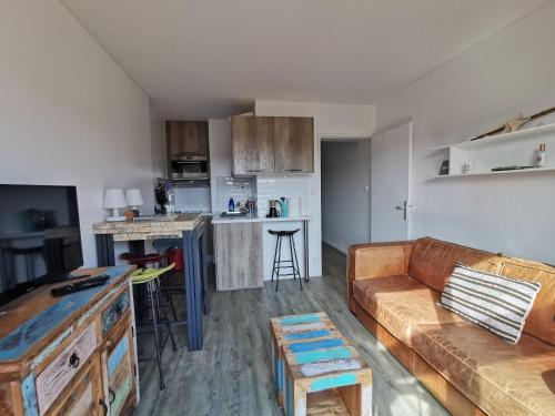 uma sala de estar com um sofá e uma cozinha em Domaine de la Coudoulière, T2 climatisé terrasse vue mer sans vis à vis plage à 100m em Six-Fours-les-Plages
