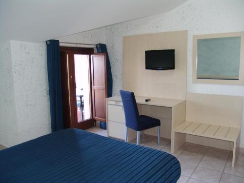 1 dormitorio con 1 cama, escritorio y TV en B&B Il Girasole, en Rogliano