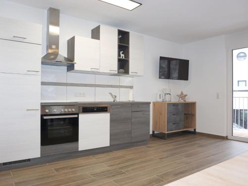 a kitchen with white cabinets and a stove at Apartment Apart Annabell by Interhome in See