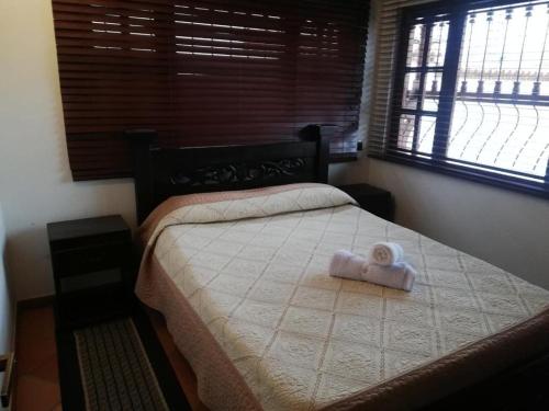 Un dormitorio con una cama con un osito de peluche. en Cabañas la villa, en Villa de Leyva