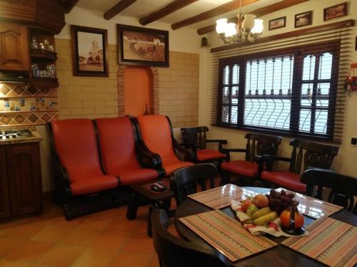 un restaurante con sillas rojas y una mesa con fruta en la mesa en Cabañas la villa, en Villa de Leyva