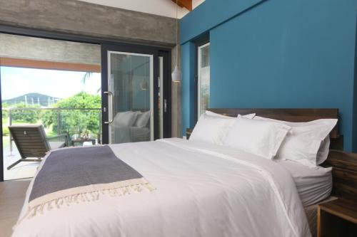a bedroom with a large white bed and a balcony at Sol Sanctum - Boutique Wellness Hotel in Gros Islet
