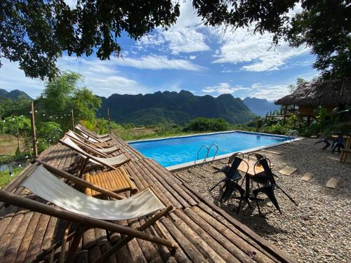 a group of chairs sitting next to a swimming pool at Pù Luông Ecolodge in Pu Luong