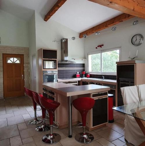 una cocina con encimera y taburetes rojos. en Villa Vincent, en Aramon