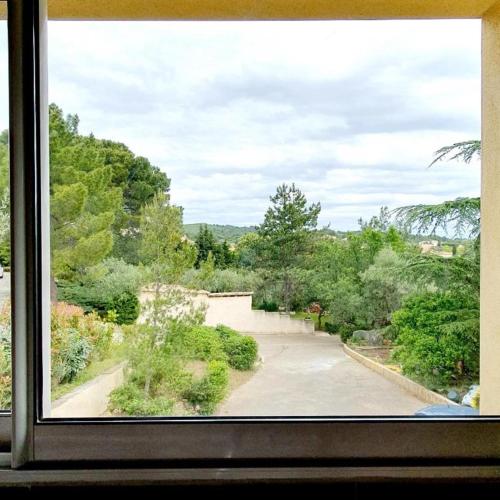 una ventana con vistas a una carretera con árboles en Villa Vincent, en Aramon