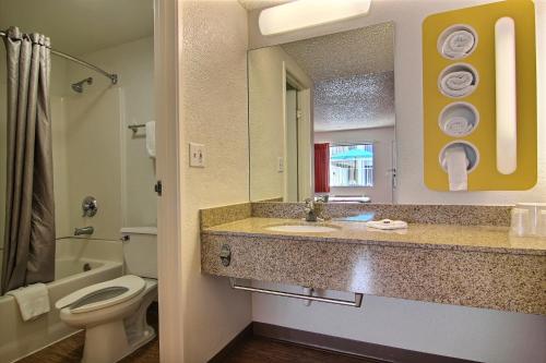 een badkamer met een wastafel, een toilet en een spiegel bij Motel 6-Albuquerque, NM - Coors Road in Albuquerque