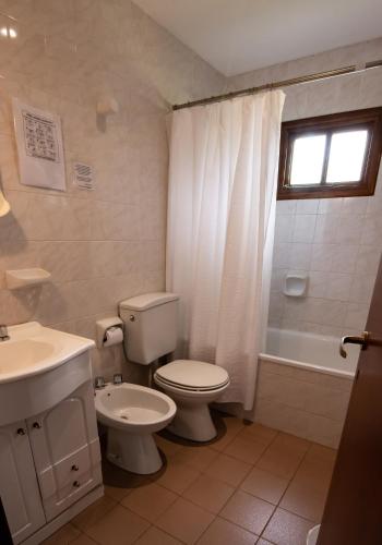 a bathroom with a toilet and a sink and a tub at Fitz Roy Hostería de Montaña - El Chaltén in El Chalten