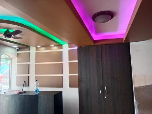 a room with a purple and green lighting on the ceiling at Blue rays in Calangute