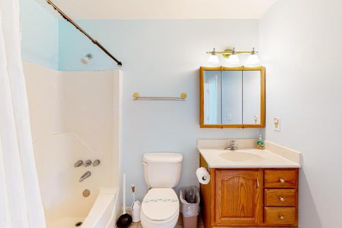 a bathroom with a toilet and a sink and a mirror at The Canal -- 337 Sandpiper in Bethany Beach