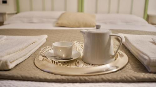 a table with a tea kettle and a cup and saucer at LO SCRIGNO COUNTRY HOUSE in Coltodino