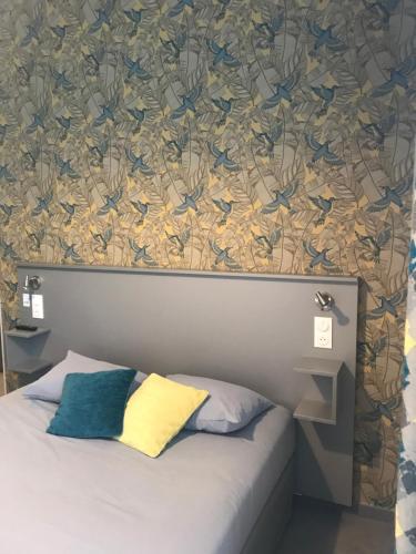 a bedroom with a bed with a wallpaper with birds on it at Smart Appart Caen République in Caen
