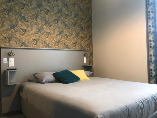 a bed with two pillows on it in a bedroom at Smart Appart Caen République in Caen