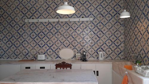 a kitchen with a table and a patterned wall at A Casa do Tenente in Faro