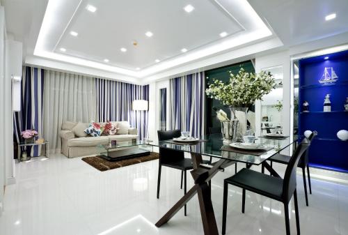 a living room with a dining room table and blue walls at Rocco Hua Hin Beach Seaview in Hua Hin